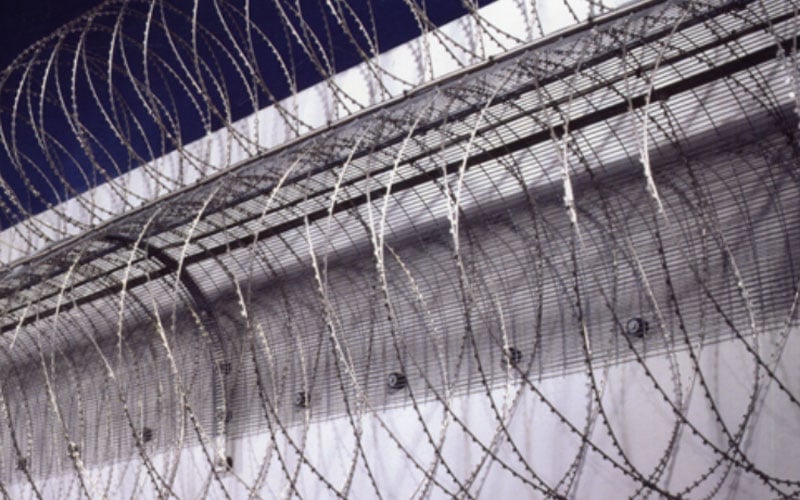 FST flexible security topping with dynamic wire mesh drape installed on a high-security perimeter fence