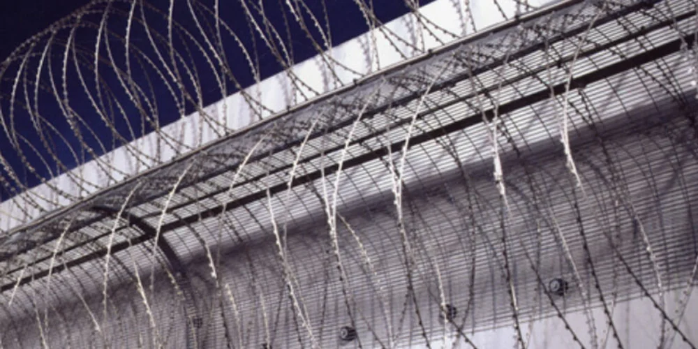 Razor wire fencing installed on a secure perimeter wall for high-security site protection in Canada